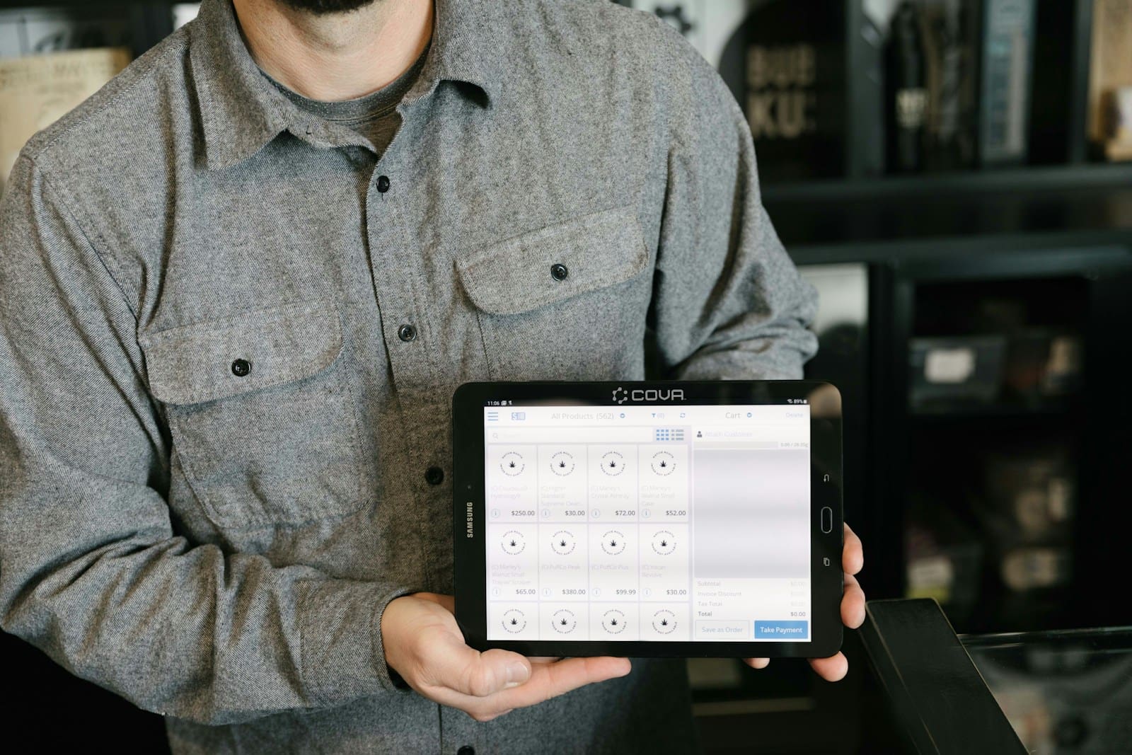 a budtender holding a tablet in his hands at a legal weed dispensary