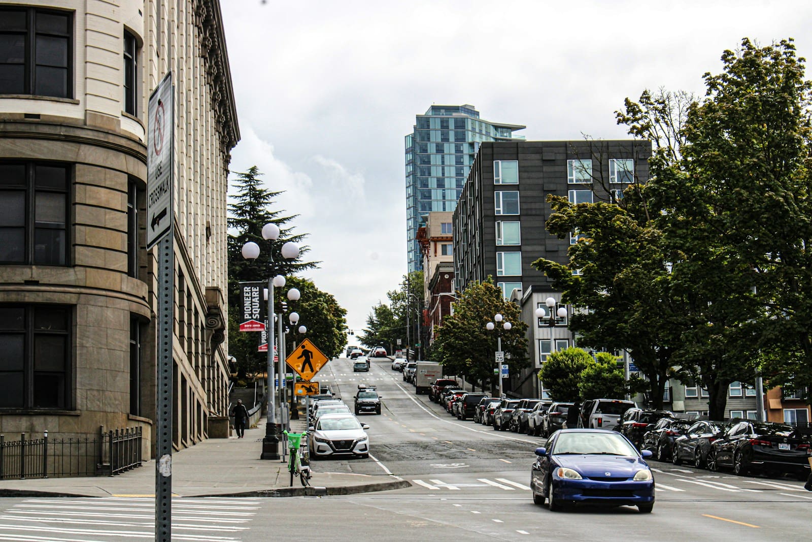A car driving down a street next to tall buildings